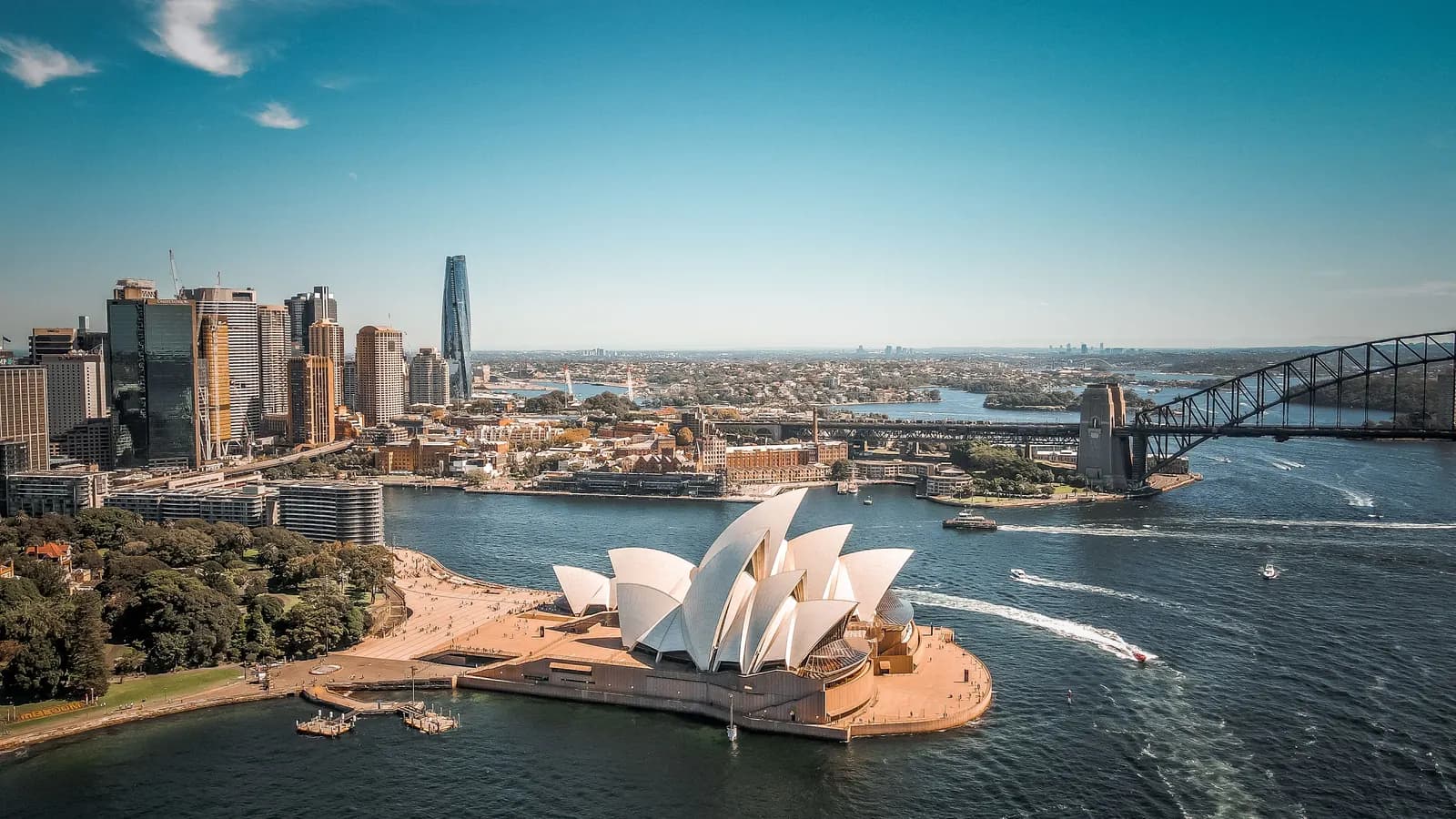 Aerial photograph of Sydney Harbour, with the Opera House in front of the city skyline and the Harbour Bridge.